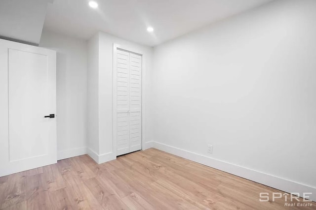 unfurnished bedroom with recessed lighting, a closet, baseboards, and light wood-style floors