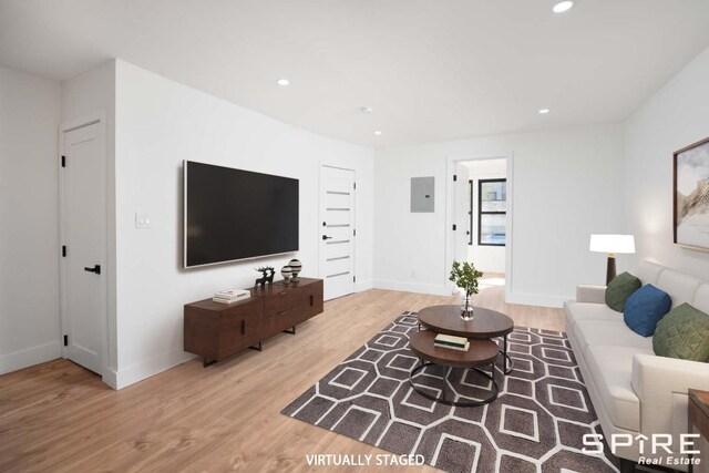 living area featuring electric panel, recessed lighting, baseboards, and wood finished floors