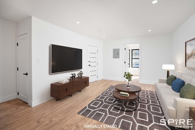 living area featuring light wood-style flooring, electric panel, and recessed lighting