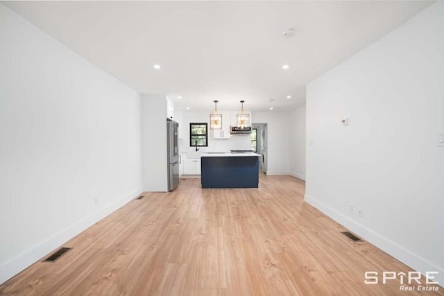 unfurnished living room with recessed lighting, light wood-type flooring, visible vents, and baseboards