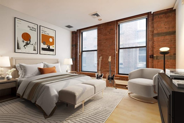 bedroom featuring brick wall and hardwood / wood-style floors