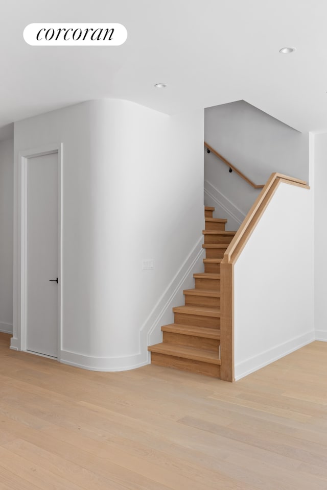 staircase featuring recessed lighting, wood finished floors, and baseboards