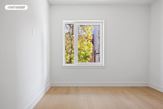 unfurnished room featuring light wood-type flooring, visible vents, and baseboards