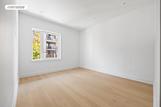 unfurnished room featuring light wood finished floors, baseboards, and visible vents