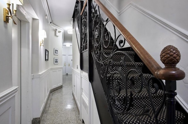 20 E 88th St Unit 2B, New York City, NY 10128 - hallway featuring dark speckled floor, a decorative wall, and a wainscoted wall