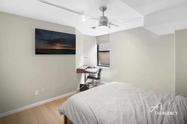 bedroom featuring light wood finished floors, a ceiling fan, and baseboards