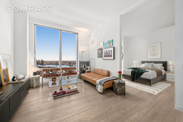 bedroom with a water view and wood finished floors