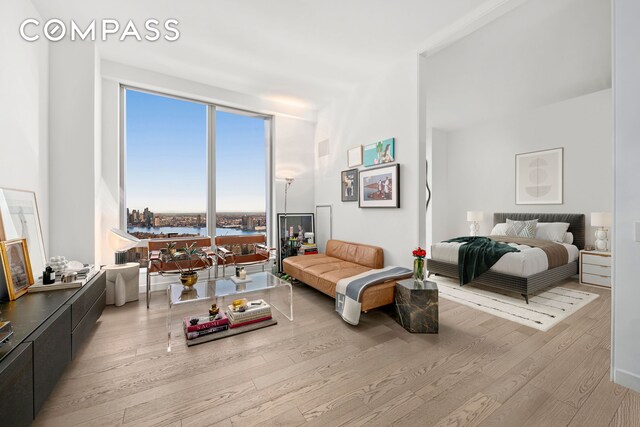 bedroom with a water view and wood finished floors