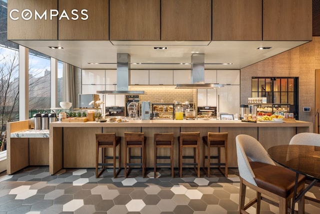 kitchen with island exhaust hood, backsplash, and exhaust hood