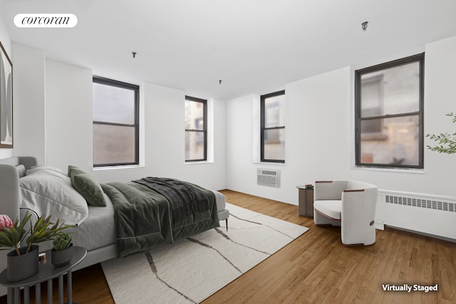 bedroom featuring radiator, visible vents, and wood finished floors