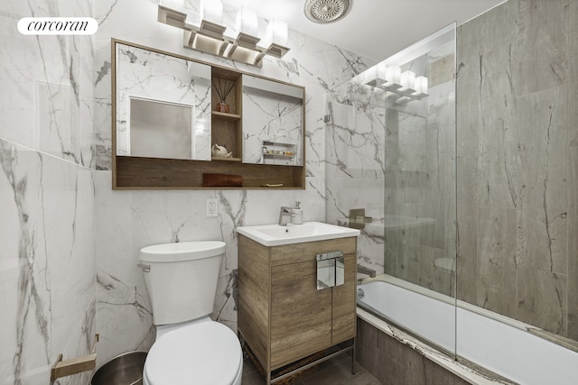 bathroom with tiled shower / bath, toilet, tile walls, and vanity