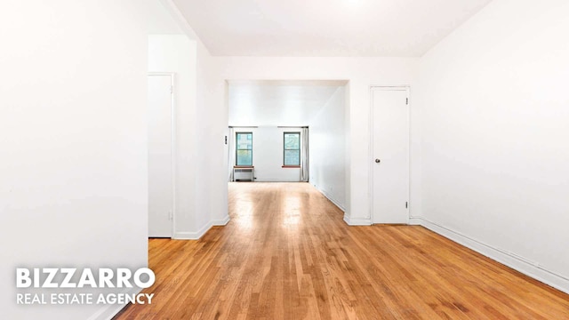 hall featuring light wood-style floors and baseboards