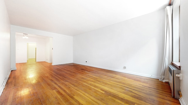 25 Indian Rd Unit 2G, New York City, NY 10034 - empty room featuring radiator heating unit, light wood-style floors, and baseboards