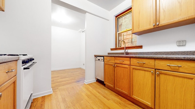 kitchen featuring gas range gas stove, a sink, dishwasher, dark countertops, and light wood-type flooring