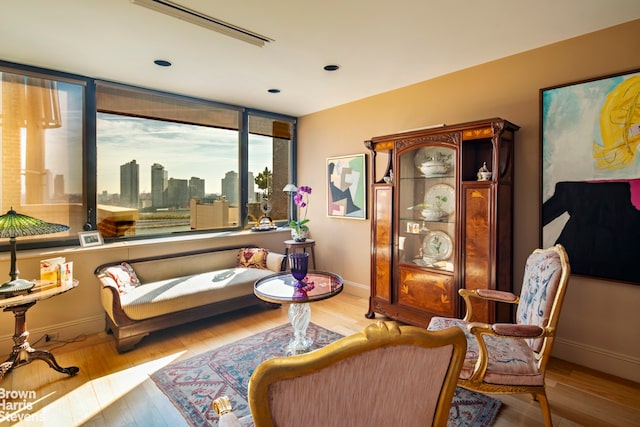 sitting room featuring a view of city, baseboards, and wood finished floors