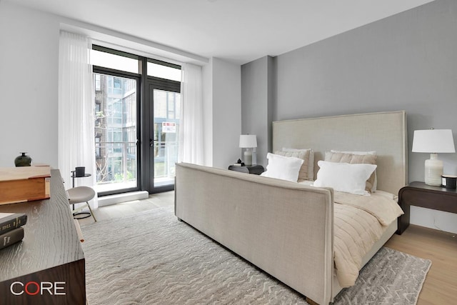 bedroom with multiple windows and light hardwood / wood-style floors