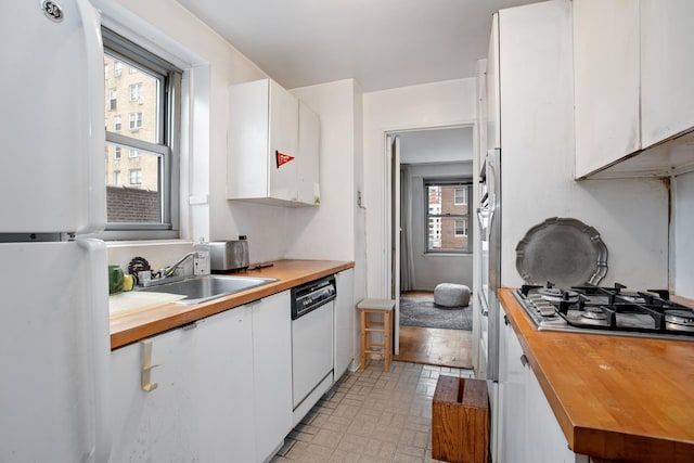 360 E 72nd St Unit B804, New York City, NY 10021 - kitchen with white appliances, butcher block counters, white cabinets, and brick patterned floors