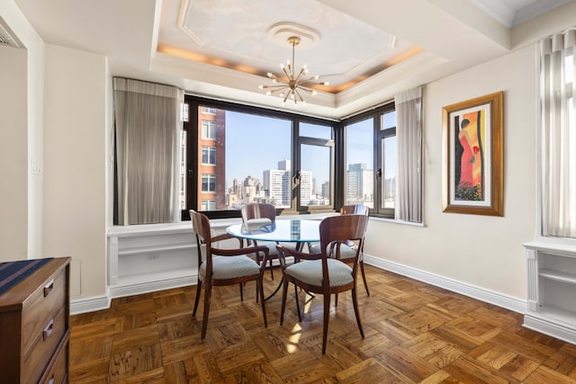 dining space featuring a tray ceiling, a notable chandelier, ornamental molding, and dark parquet flooring