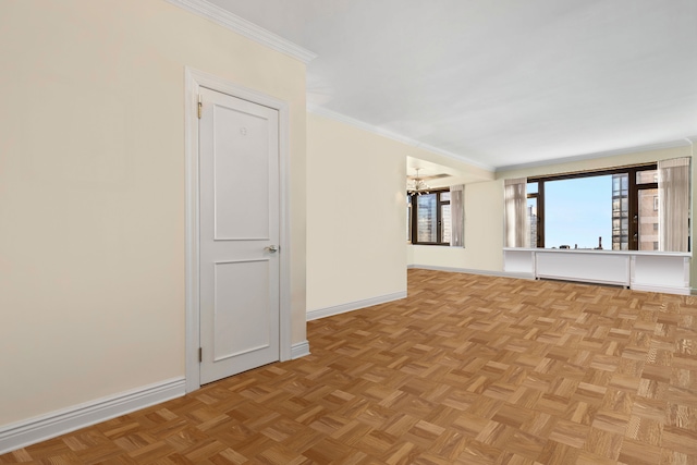 unfurnished room featuring crown molding, baseboards, and a chandelier