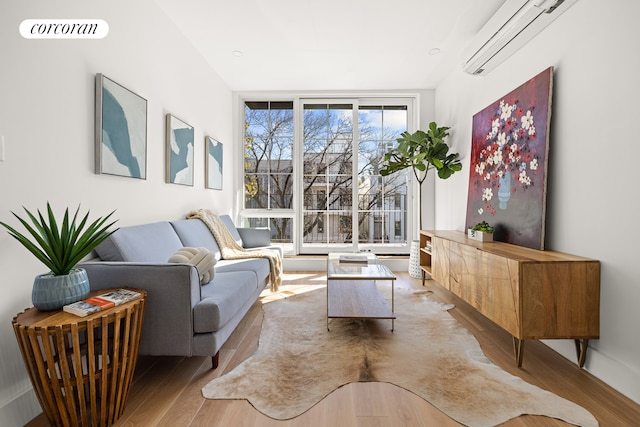 living area featuring visible vents, a wall unit AC, and wood finished floors