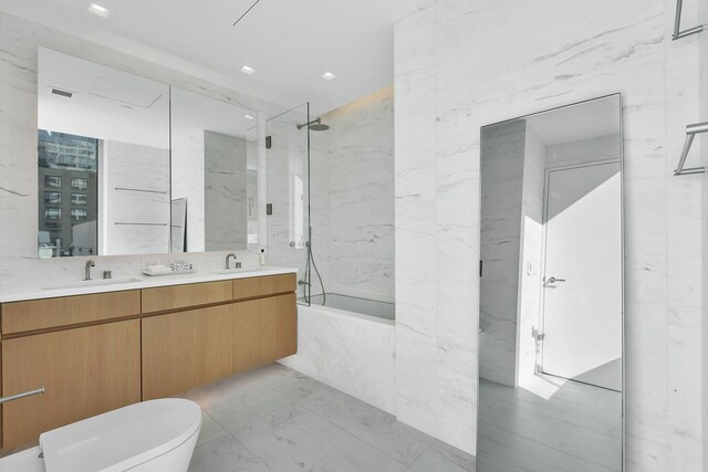 full bathroom featuring vanity, toilet, tile walls, and tiled shower / bath