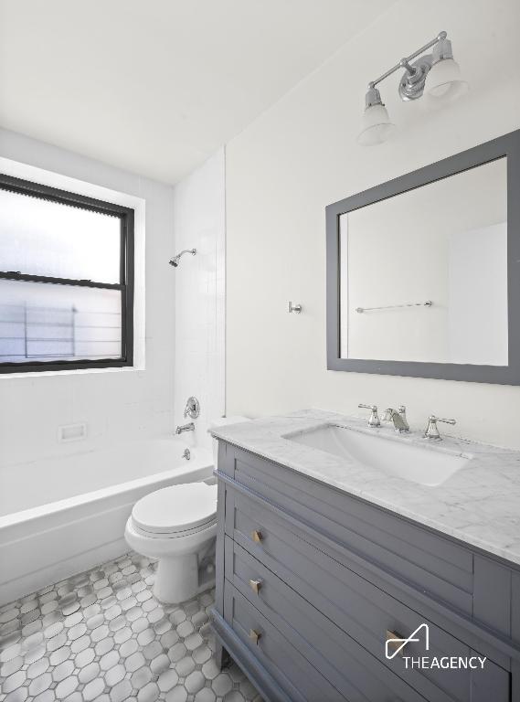 bathroom featuring tub / shower combination, vanity, and toilet