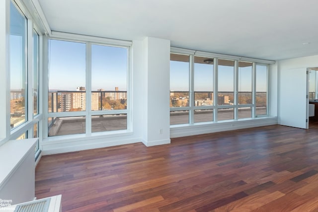 living room with a wealth of natural light, hardwood / wood-style floors, and expansive windows