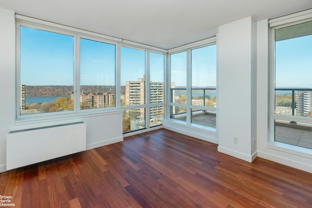 unfurnished sunroom featuring a water view and radiator