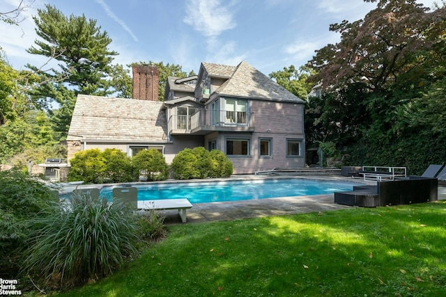 800 W 231st St, New York City, NY 10463 - back of house with a balcony, a lawn, an outdoor pool, a chimney, and a high end roof