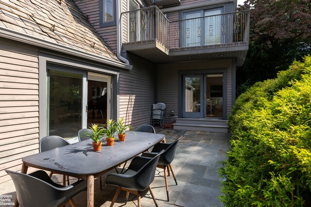 view of patio / terrace featuring entry steps, outdoor dining area, and a balcony