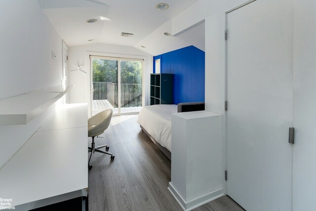 bedroom with lofted ceiling, wood finished floors, visible vents, and access to exterior