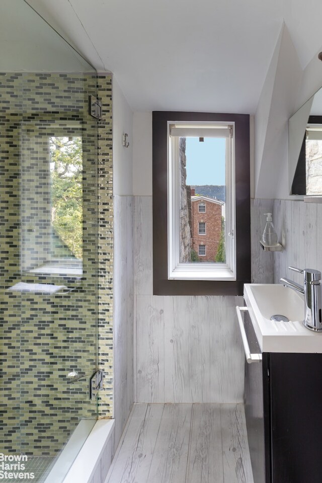 800 W 231st St, New York City, NY 10463 - full bathroom with vanity, a shower stall, tile walls, and a wainscoted wall