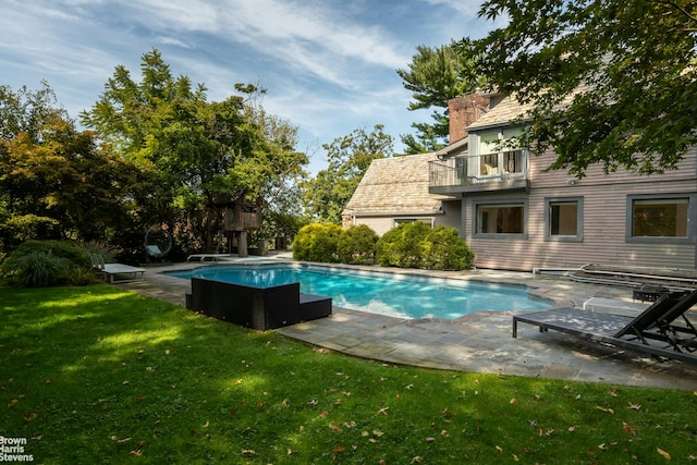 outdoor pool with a patio area and a lawn