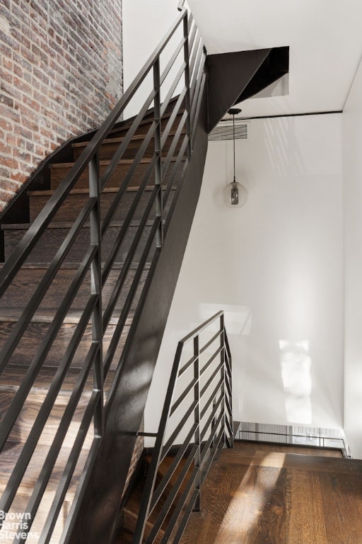 stairs featuring a high ceiling and wood finished floors