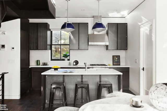 kitchen with a kitchen island with sink, pendant lighting, light countertops, and modern cabinets