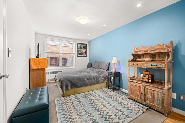 bedroom with hardwood / wood-style floors and radiator heating unit