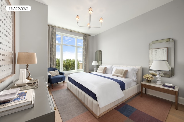 bedroom featuring a notable chandelier, baseboards, and wood finished floors