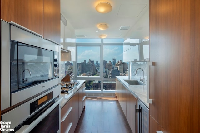 kitchen with a view of city, appliances with stainless steel finishes, a sink, modern cabinets, and beverage cooler