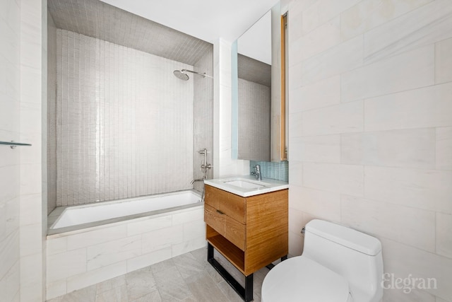 full bathroom featuring toilet, tiled shower / bath, and vanity