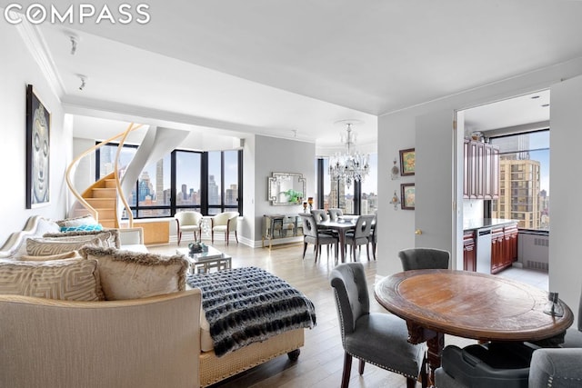 living room with a notable chandelier, a healthy amount of sunlight, hardwood / wood-style flooring, and radiator heating unit