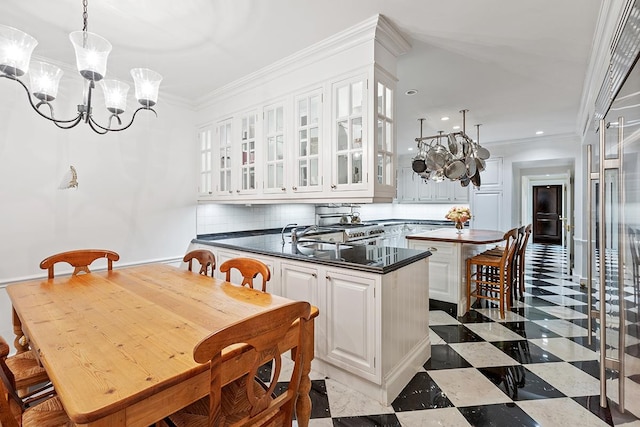 6 E 69th St, New York City, NY 10021 - kitchen featuring dark countertops, a chandelier, white cabinets, glass insert cabinets, and decorative backsplash