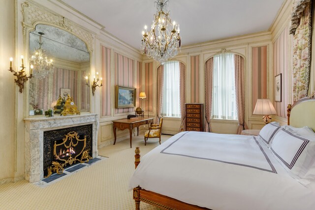 4 E 80th St, New York City, NY 10075 - bedroom featuring carpet flooring, crown molding, a chandelier, and a fireplace