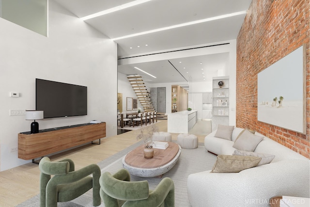 living area with brick wall and wood finished floors