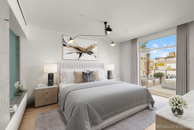 bedroom featuring access to exterior and light wood-style flooring