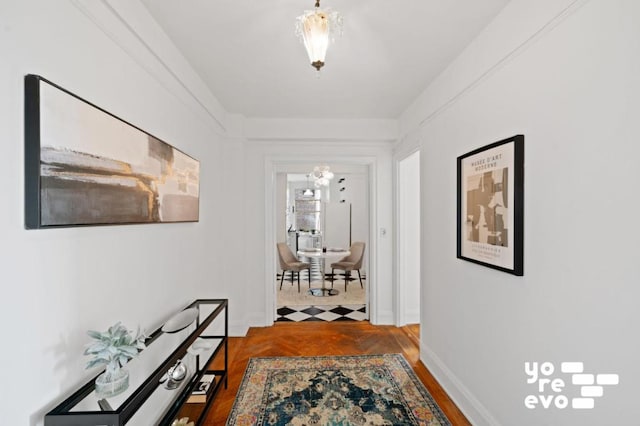 corridor featuring hardwood / wood-style flooring and a notable chandelier