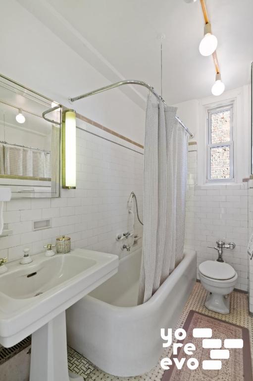 full bathroom featuring tasteful backsplash, toilet, tile walls, sink, and shower / tub combo with curtain