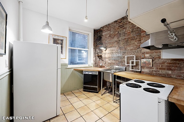 kitchen featuring white appliances, brick wall, wood counters, and wainscoting