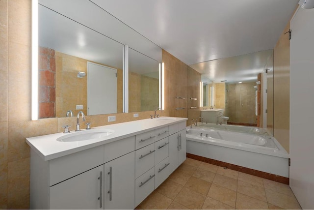 bathroom featuring toilet, vanity, tile patterned floors, and a bath