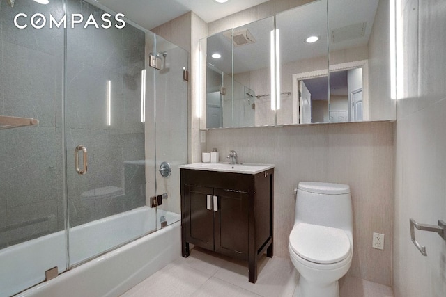 full bathroom with tile patterned flooring, vanity, combined bath / shower with glass door, and toilet