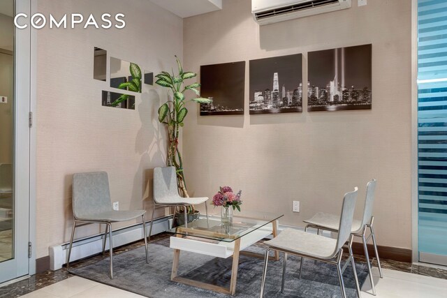 sitting room with baseboards, baseboard heating, and an AC wall unit